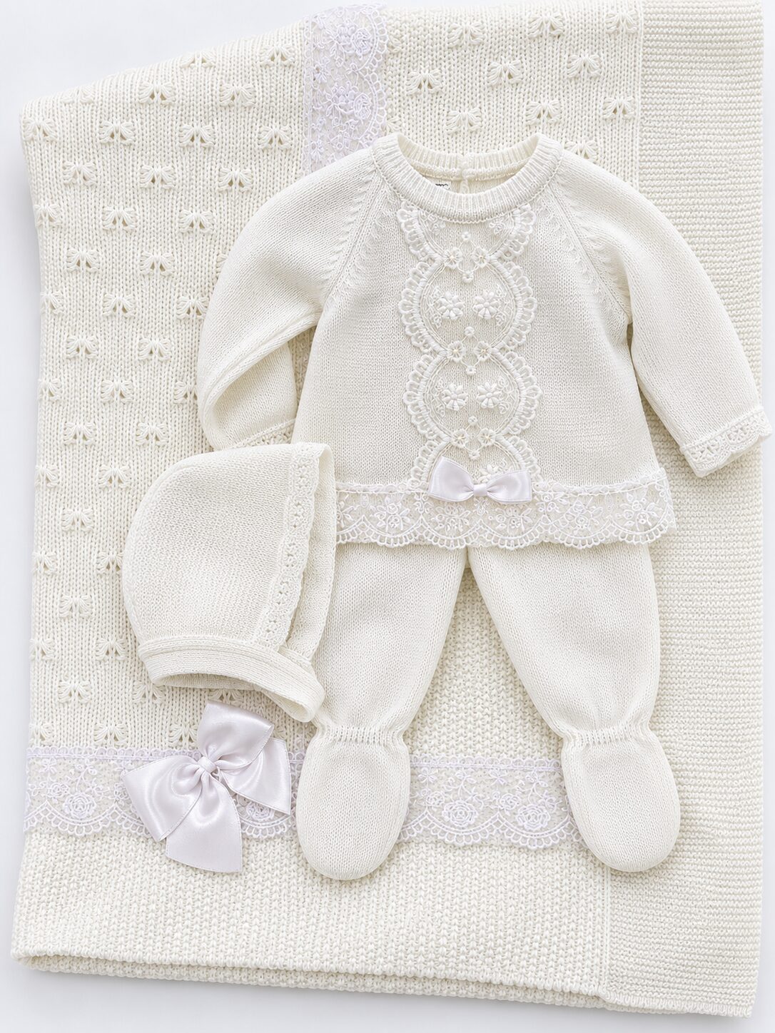 Conjunto de bebé en marfil sobre manta de punto Pack Primera Puesta: Blanco con Traje de Punto de 3 Piezas y Toquilla con Encaje 3